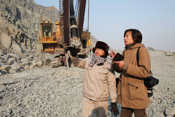 新华社记者(右)在辽宁鞍钢集团齐大山铁矿矿区采访新时期道德模范