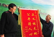 呼格吉勒图父母向新华社内蒙古分社和记者汤计赠送锦旗