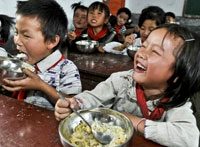 贵州省普安县龙吟镇丫口小学一年级新生开心地吃午餐