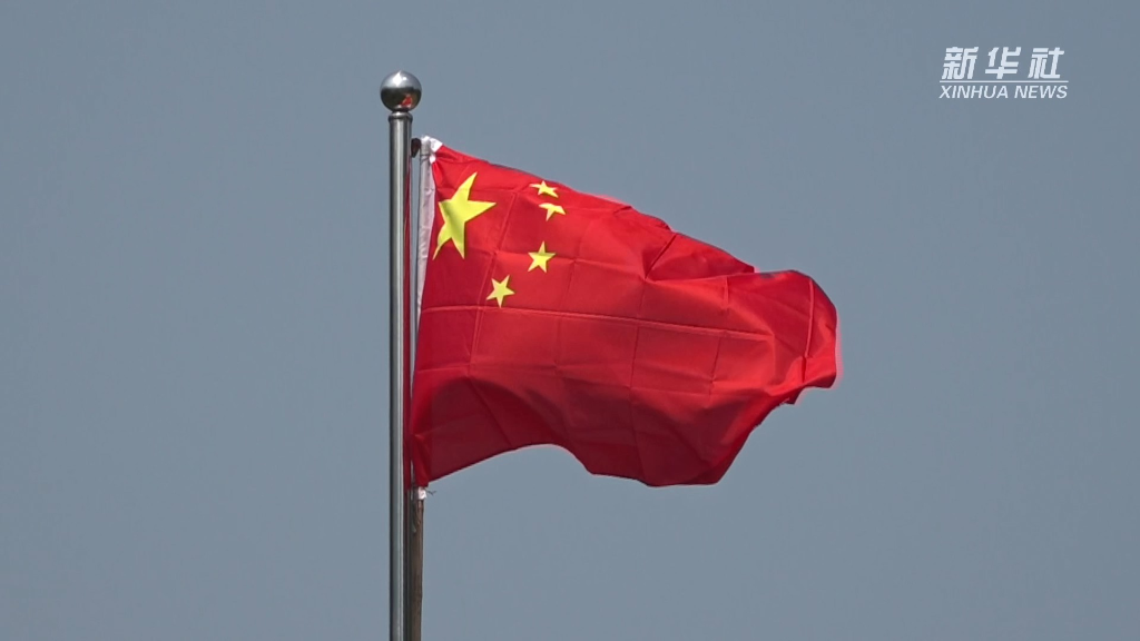 鲜艳的五星红旗冉冉升起,升旗人是江西省萍乡市东桥村村民汤春梅和她