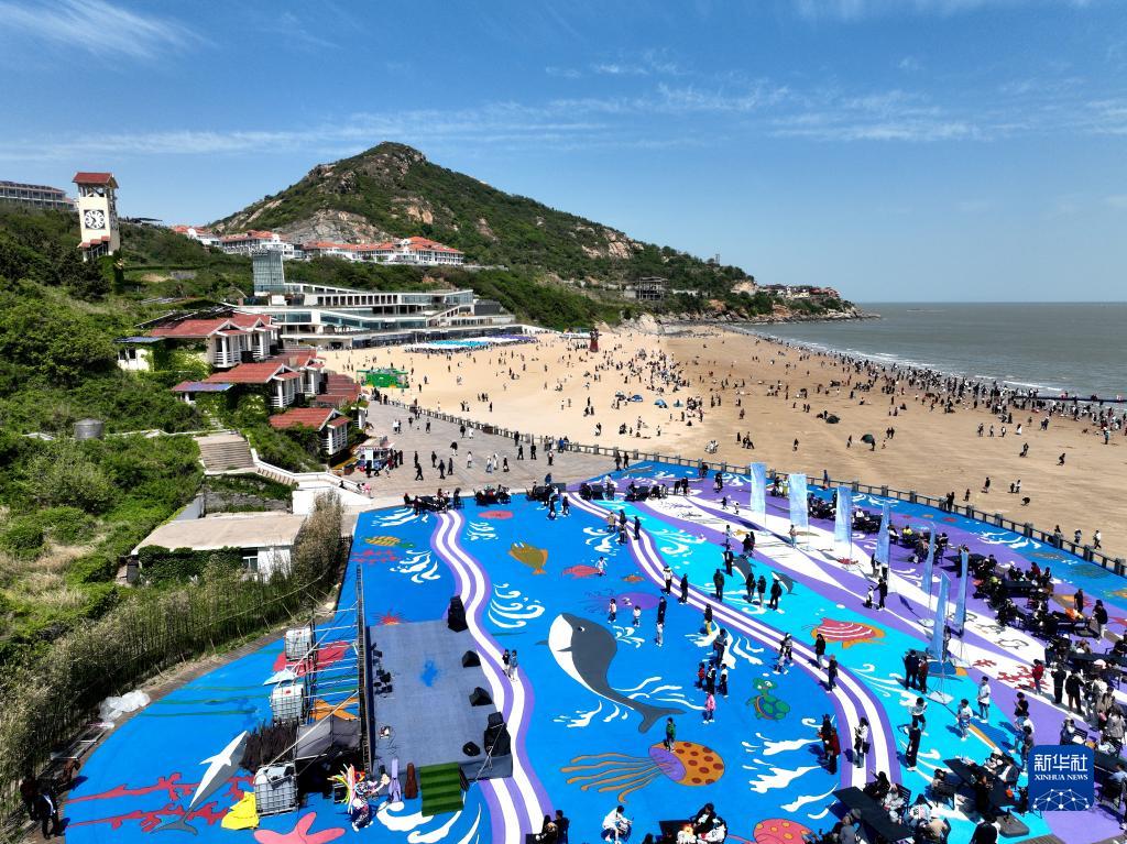 4月29日,游客在江苏省连云港市连岛大沙湾游乐园海滨浴场观光游玩(无