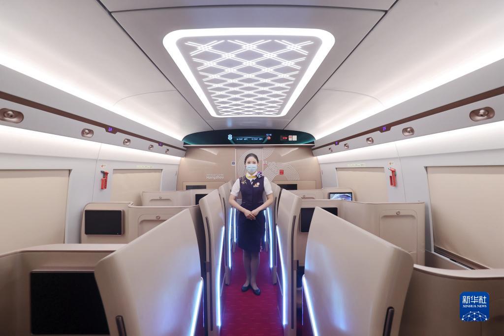 8月4日,在高铁德清站,乘务员在复兴号亚运智能动车组列车上引导服务.