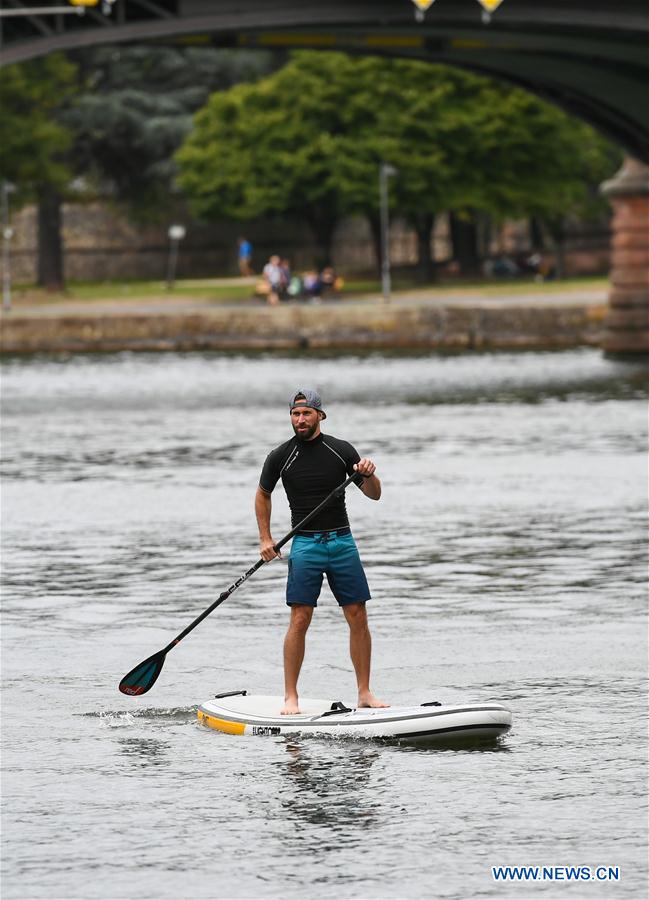 standuppaddleboardingenthusiastsexerciseinfrankfurtgermany