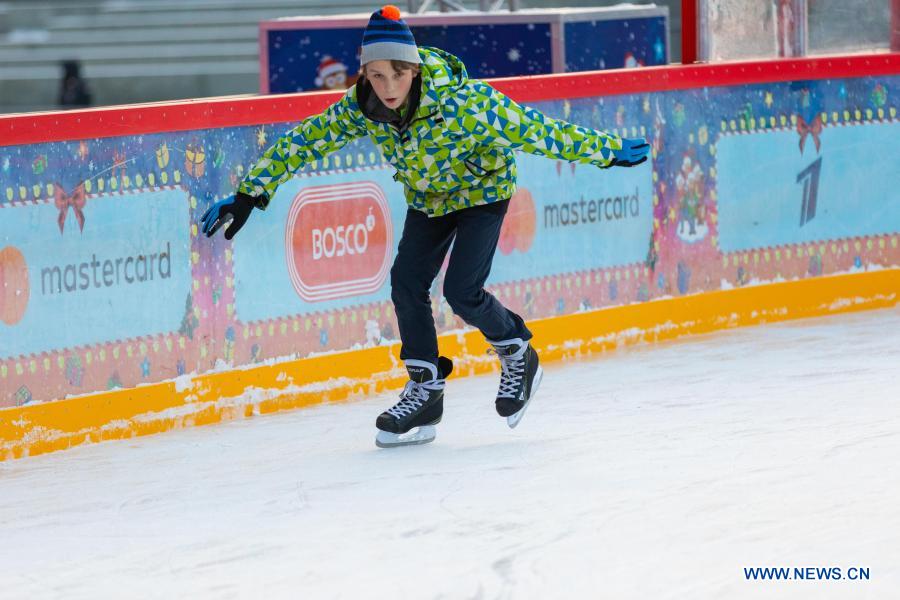 people skate on gum ice rink at red square in moscow, russia