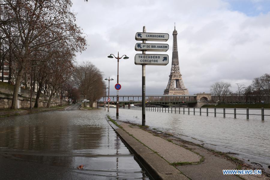 the eiffel tower is seen on the flooded banks of the seine river