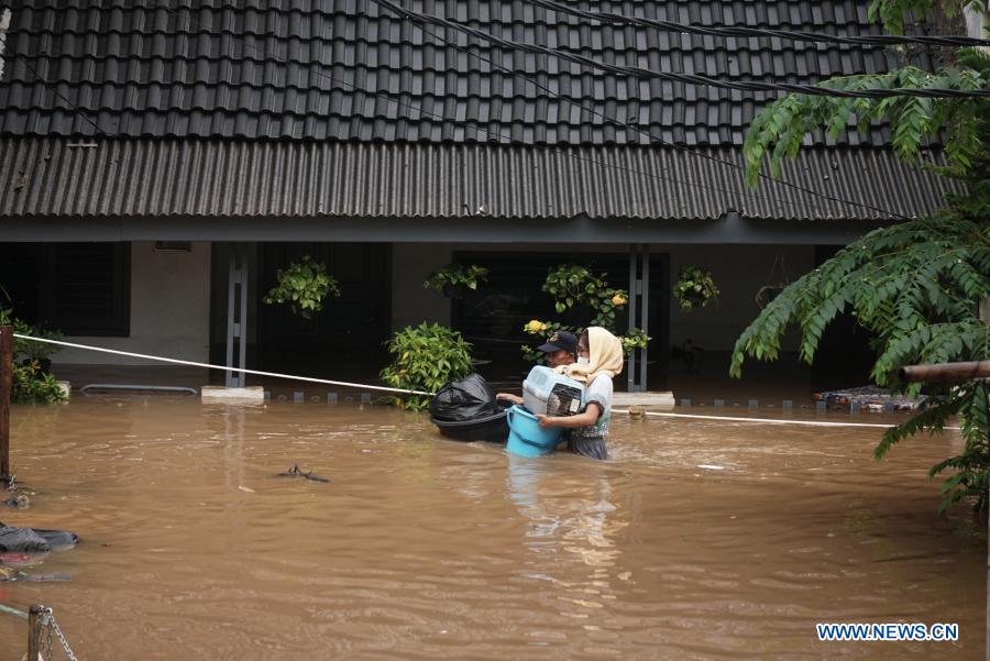 peoplewadethroughfloodwaterinjakartaindonesia
