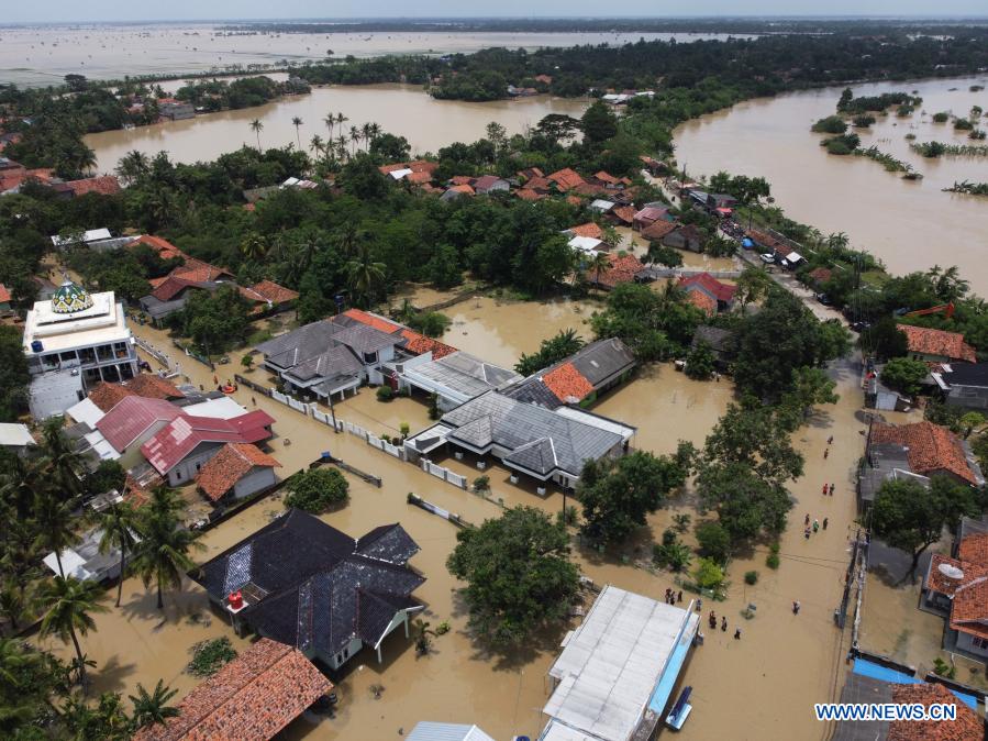 people walk through flood water in bekasi, indonesia - xinhua