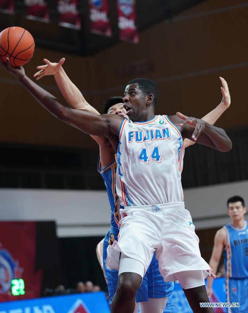 andrew nicholson (r) of fujian sturgeons goes to the basket