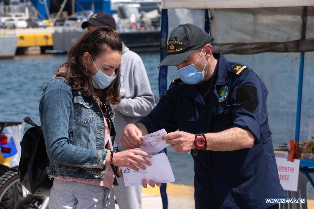 members of greek coast guard check passengers travel documents