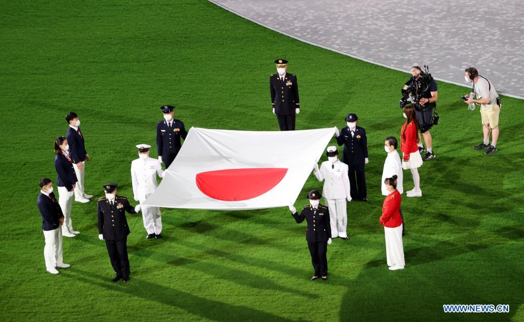 flag bearers carry the japanese national flag into the olympic