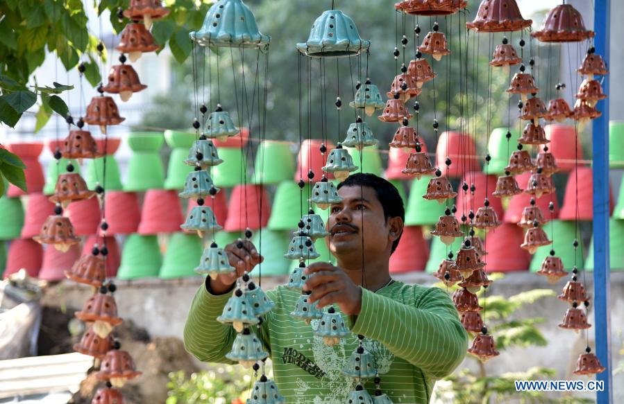 artist arranges decorative items at shop in jammu