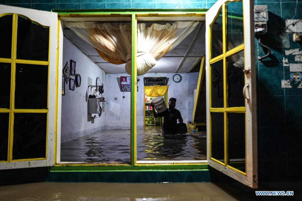 people walk through flood water in north sumatra, indonesia