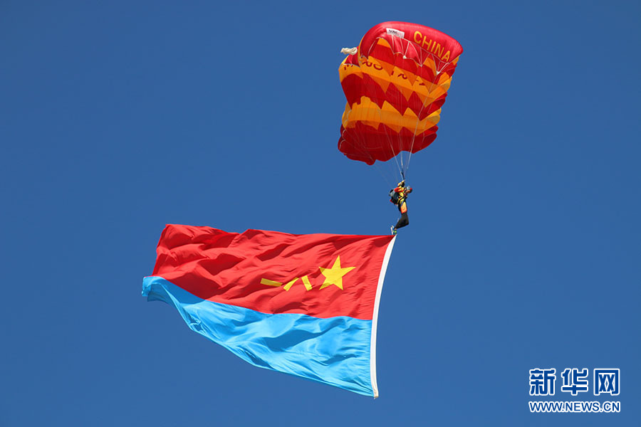 空军跳伞大队表演项目"蓝天先锋",在空中展开空军军旗.陈曦 摄