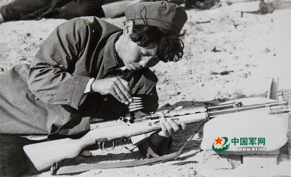 上世纪六十年代,一位女民兵实弹射击训练时安装子弹.