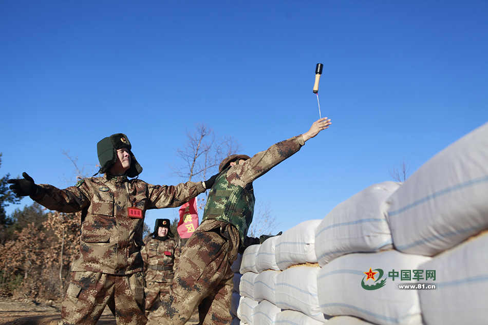 11月25日,一名指挥员正在指导新战士投掷手榴弹的动作.