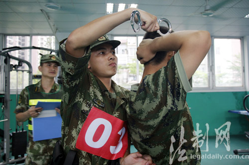 图为参训官兵用手铐进行上拷训练