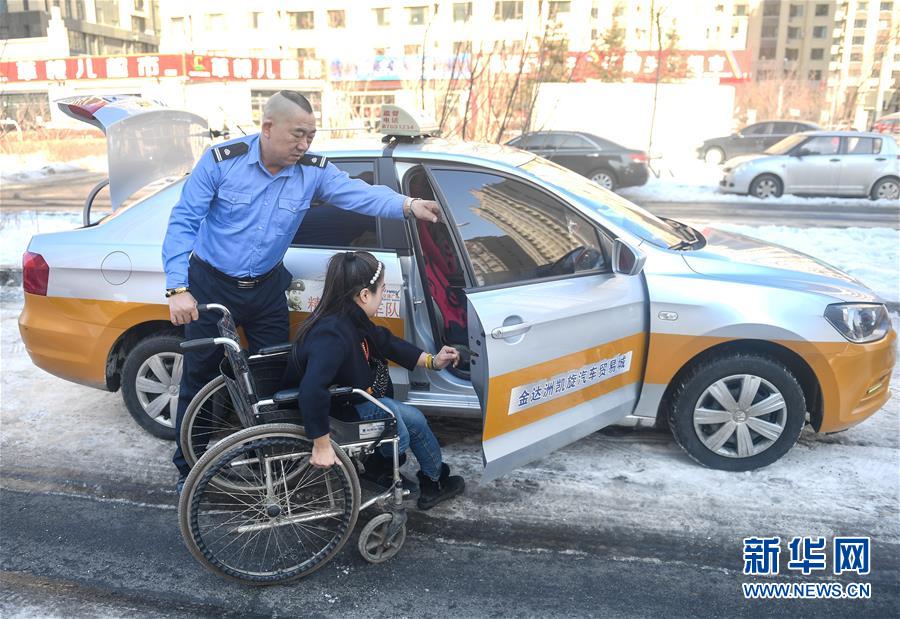 3月5日,长春"精英雷锋车队"队员杜桐在接送一位残疾人.