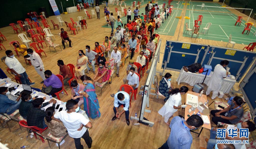 4月22日,居民在印度东北部城市高哈蒂的体育场排队接种新冠疫苗.