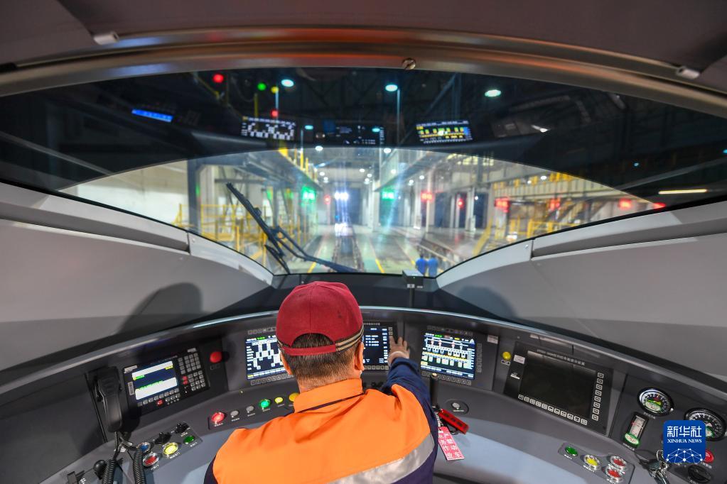 10月1日,贺海龙在高铁驾驶室进行设备数据检测试验.