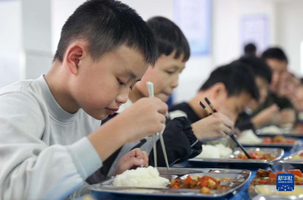 10月19日,四川省华蓥市高兴镇小学的学生在食堂吃午饭.