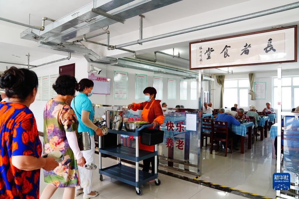 7月29日,桓台县马桥镇前金村"长者食堂"的工作人员在为老人打餐.