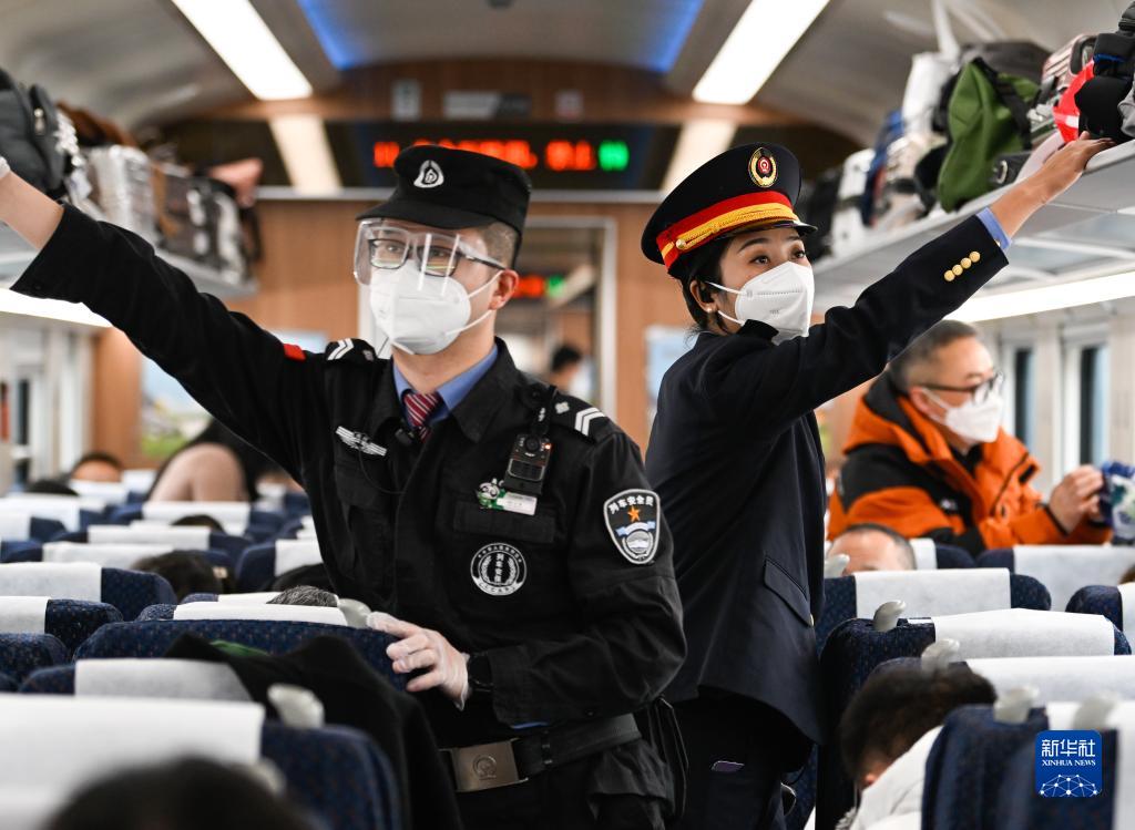 1月11日,在c43次列车上,阿依布卡(右)和列车安全员在车厢巡视.