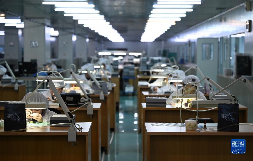 在天津海鸥表业集团生产车间内,员工在操作台前组装手表(5月12日摄).