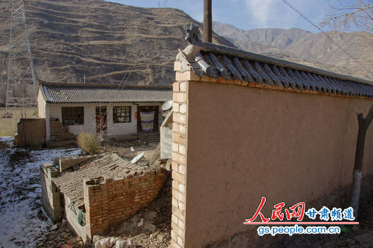 甘肃漳县殪虎桥乡东桥村的&ldquo;遮羞墙&rdquo;挡住农户房屋（人民网记者 高翔 张鹏 隋欣 摄）