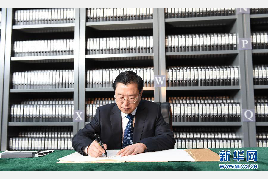 12月13日，中共中央政治局常委、全国人大常委会委员长张德江在侵华日军南京大屠杀遇难同胞纪念馆展厅，参观《人类的浩劫－－侵华日军南京大屠杀史实展》。这是参观结束时，张德江在签字簿上签名。新华社记者 李学仁 摄 