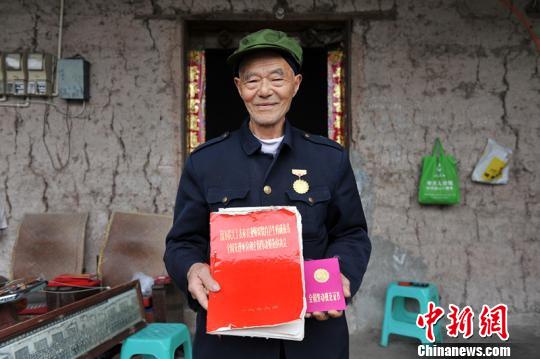 83岁老劳模许定书在重庆市江津区带着儿孙开养猪场做&ldquo;猪倌&rdquo;，1979年曾被评为全国劳动模范。图为许定书在养猪场喂猪。　苏展　摄