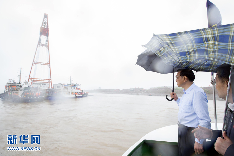 这是李克强乘指挥船抵达沉船附近，冒雨登上甲板，仔细查看救援情况。 新华社记者 黄敬文 摄