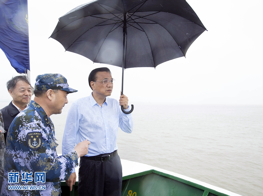 这是李克强乘指挥船抵达沉船附近，冒雨登上甲板，仔细查看救援情况。 新华社记者 黄敬文 摄