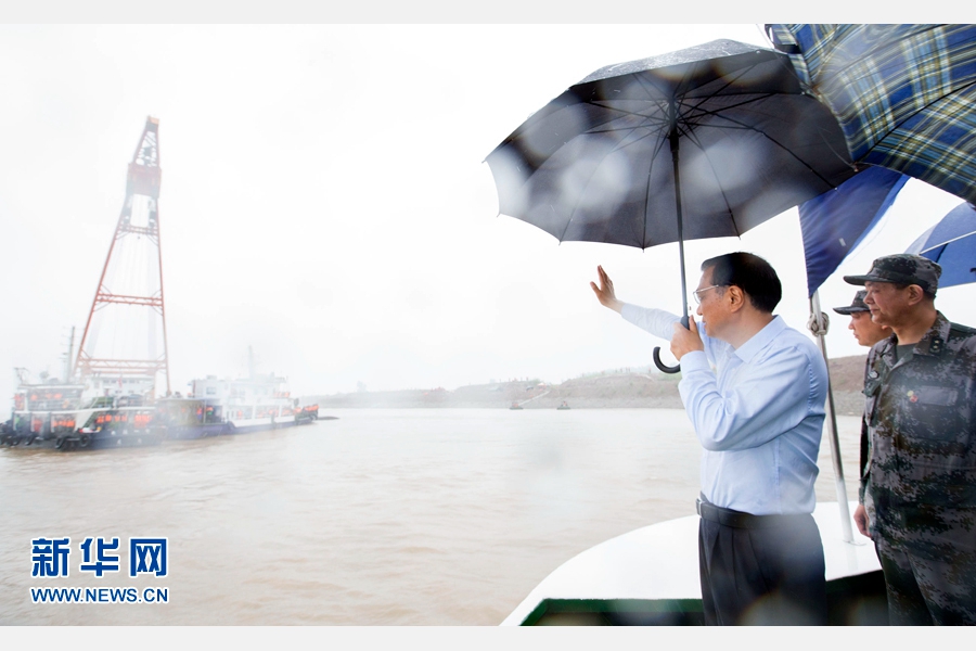 这是李克强乘指挥船抵达沉船附近，冒雨登上甲板，挥手向救援人员致以问候。 新华社记者 黄敬文 摄