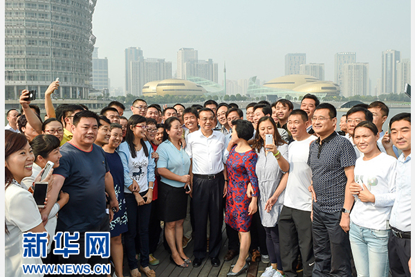 这是9月25日，李克强在郑州郑东新区同市民合影留念。新华社记者谢环驰摄