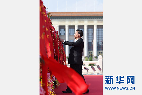 9月30日上午，党和国家领导人习近平、李克强、张德江、刘云山、王岐山、张高丽等来到北京天安门广场，出席烈士纪念日向人民英雄敬献花篮仪式。这是习近平整理花篮上的缎带。　　新华社记者 谢环驰 摄