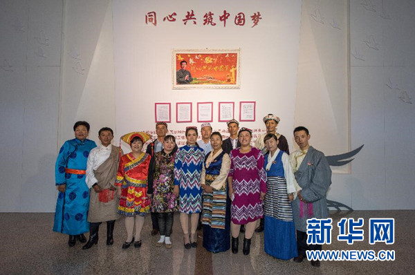     13位基层民族团结优秀代表齐聚北京，在来自新疆的艾尼瓦尔姐妹敬献给习近平总书记的&ldquo;同心共筑中国梦&rdquo;十字绣作品下合影（9月30日摄）。金秋十月，水天澄碧。在中华人民共和国第66个国庆日到来前夕，习近平总书记在人民大会堂亲切会见了13位民族团结优秀代表，向他们致以节日的祝贺，勉励他们继续当好民族团结的使者。新华社记者 陈益宸 摄