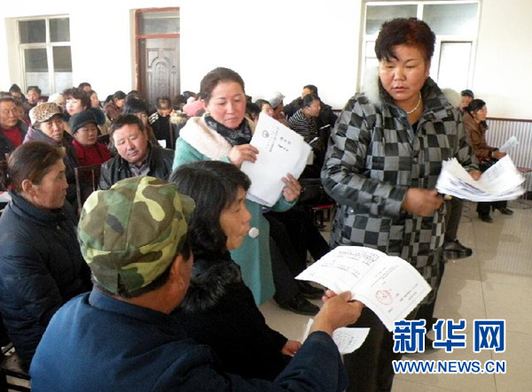     内蒙古自治区阿拉善盟额济纳旗赛汉陶来苏木孟格图嘎查党支部书记乌云苏依拉（右一）在嘎查的两委班子选举会上为牧民发选票（2012年12月28日摄）。金秋十月，水天澄碧。在中华人民共和国第66个国庆日到来前夕，习近平总书记在人民大会堂亲切会见了13位民族团结优秀代表，向他们致以节日的祝贺，勉励他们继续当好民族团结的使者。新华社发