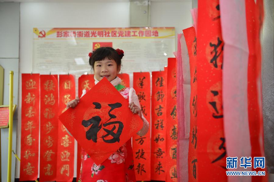 南昌市东湖区光明社区居民涂佳欣钰小朋友手捧自己写的福字。总书记参观社区时专门夸赞涂佳欣钰书法写得好（2月3日摄）。新华社记者 周密 摄 