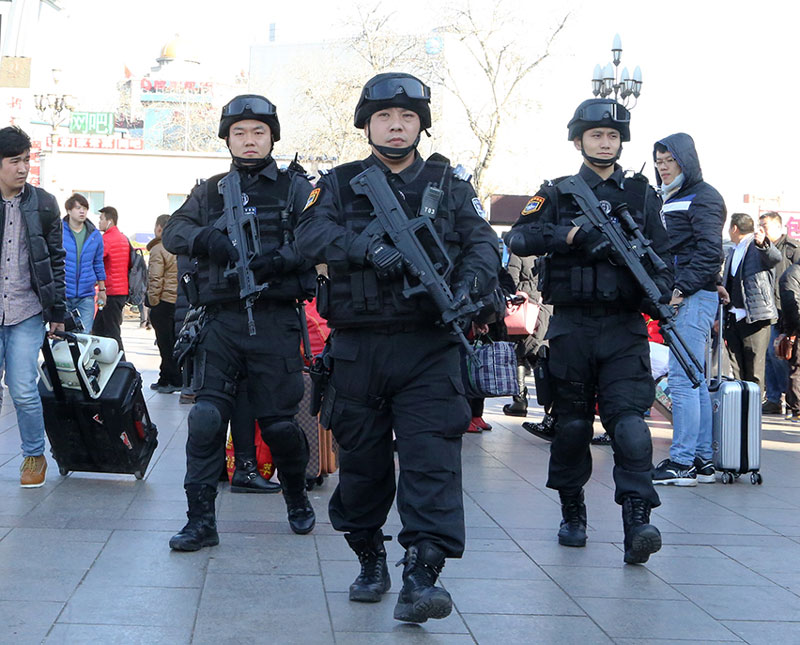 图为刘立海带领队员在北京站广场成三角战术队形武装巡逻.