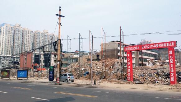 p47-1 2015 年 5 月 31 日,在社区干部的带头拆迁下,亲贤社区的“城中村改造”拉开帷幕。由于前期“清产核资”及补偿标准等因素,拆迁改造工作推进并不顺利。图为位于体育西路东侧集体所有的商铺率先被拆迁完毕,用于遮挡的围挡正在施工中。(拍摄 2015 年 9 月 16 日)