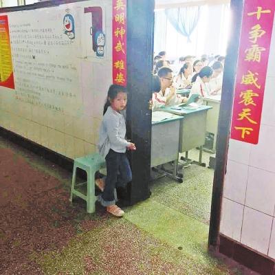 教室外,小女孩双眼露出害怕神情。