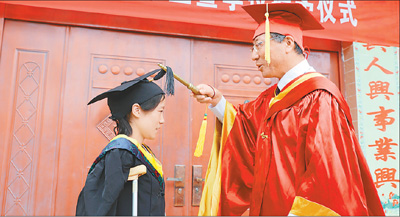 图为孙其信校长为王功娜拨穗。