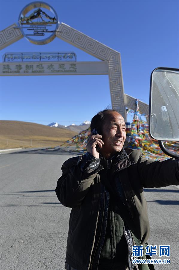 老杨在318国道西藏定日县境内接听一名顾客打来的电话(10月28日摄).