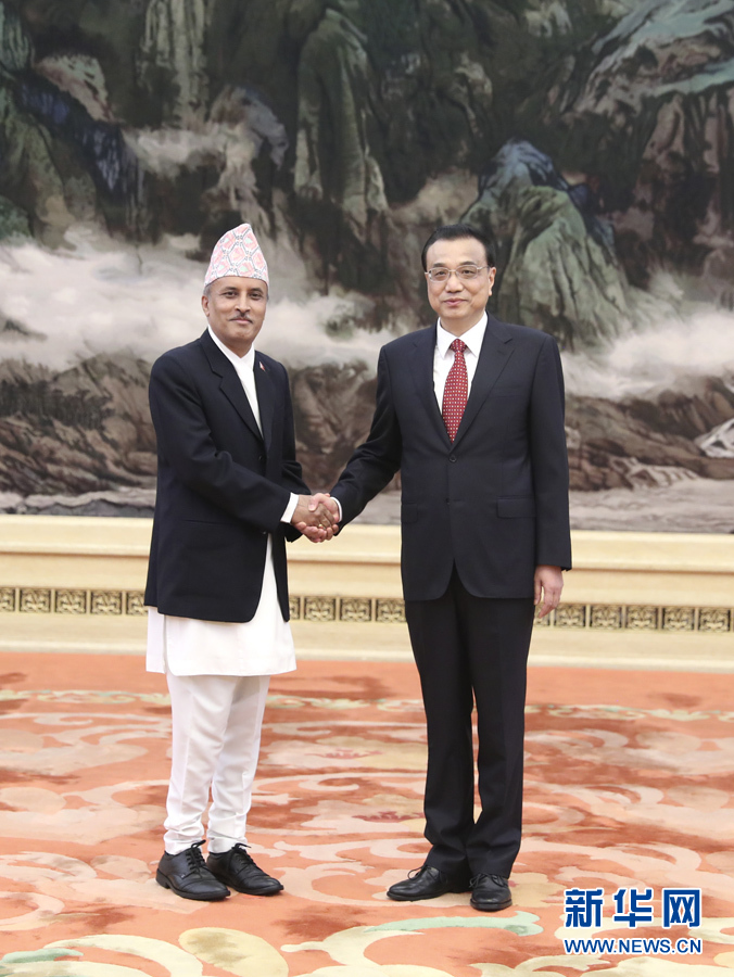 9月30日，在中华人民共和国成立68周年前夕，国务院总理李克强在北京人民大会堂会见过去一年中到任的40位外国驻华使节。这是李克强与尼泊尔驻华大使鲍德尔握手。新华社记者马占成摄