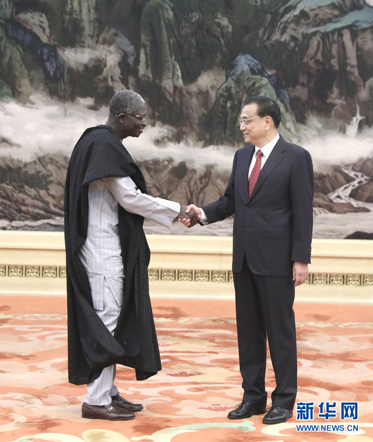 9月30日，在中华人民共和国成立68周年前夕，国务院总理李克强在北京人民大会堂会见过去一年中到任的40位外国驻华使节。这是李克强与贝宁驻华大使阿多韦兰德握手。新华社记者马占成摄