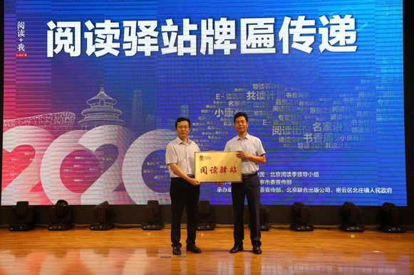 北京联合出版公司董事长赵红仕代表主办方向北庄镇人大主席马德强传递