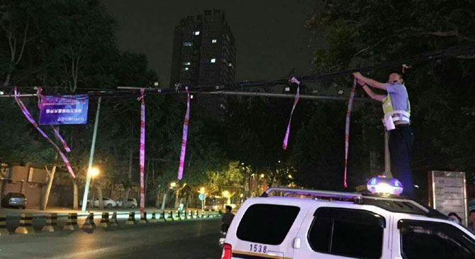 西安一交警为保畅通 爬车顶托电缆近一小时