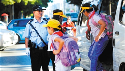 海淀区实验小学门口，高宝来正帮助来上学的小学生下车