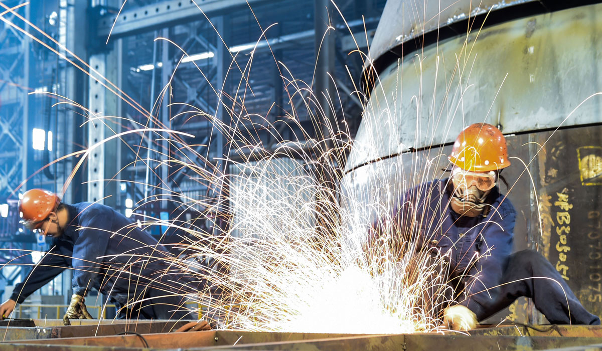 在河南省洛阳市中信重工铆焊车间,工人在焊接矿用磨机筒体的加急配件.