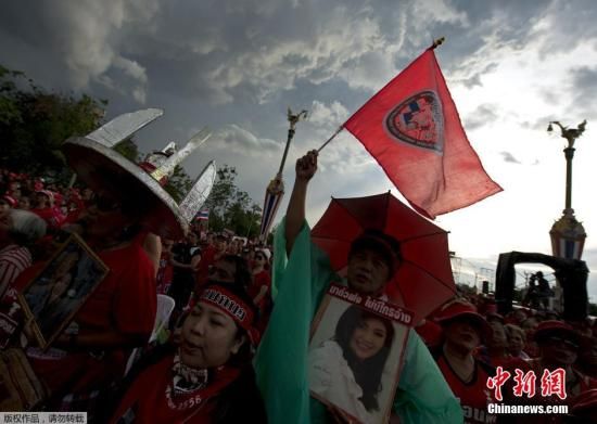 资料图：当地时间2014年5月11日，泰国曼谷，泰国&ldquo;红衫军&rdquo;高举英拉和他信的头像举行大规模集会，声援政府并抗议宪法法院等独立机构的&ldquo;不公&rdquo;。